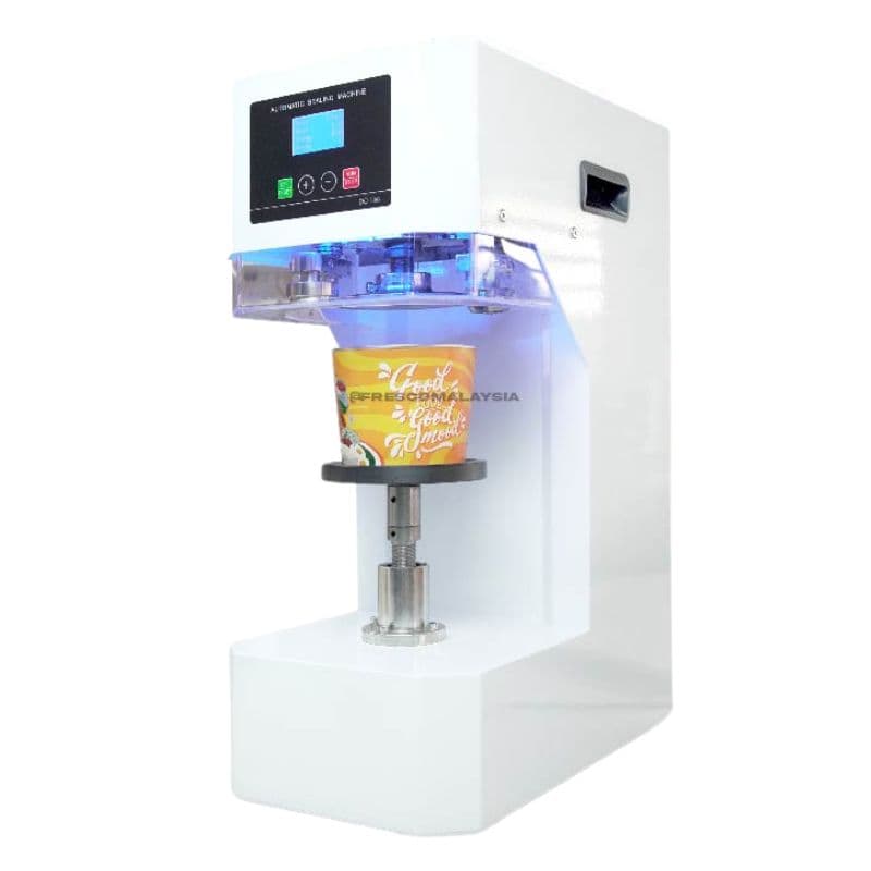 The Fully Auto Cup Sealing Machine Drink Packaging Sealer FWY-680, with a digital display, expertly seals a cup labeled "Good Food" under soothing blue lightâan ideal drink packaging solution.