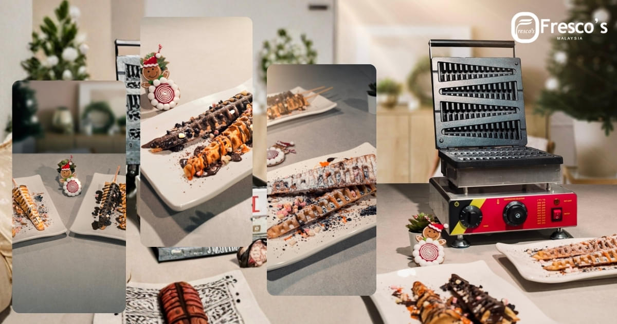 A table displays several plates of decorated waffle sticks, a small festive figure, and a waffle stick maker, with the Fresco's Malaysia logo in the background.