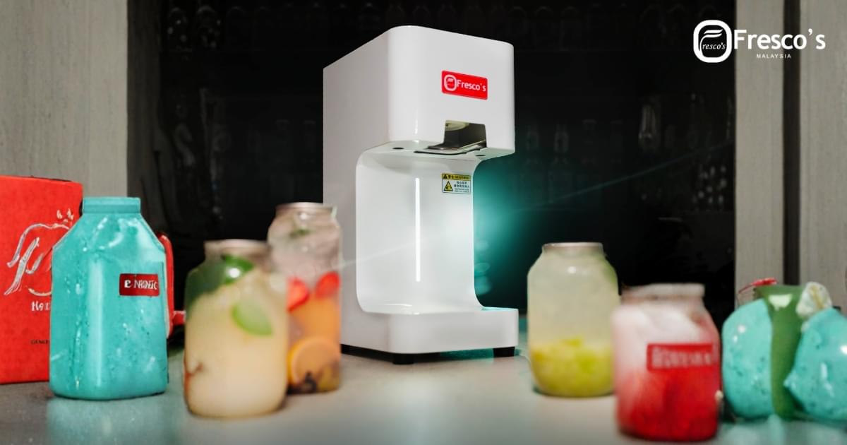 A white Fresco’s beverage machine sits on a counter beside a Professional Croffle Maker, surrounded by colorful drinks in glass jars.